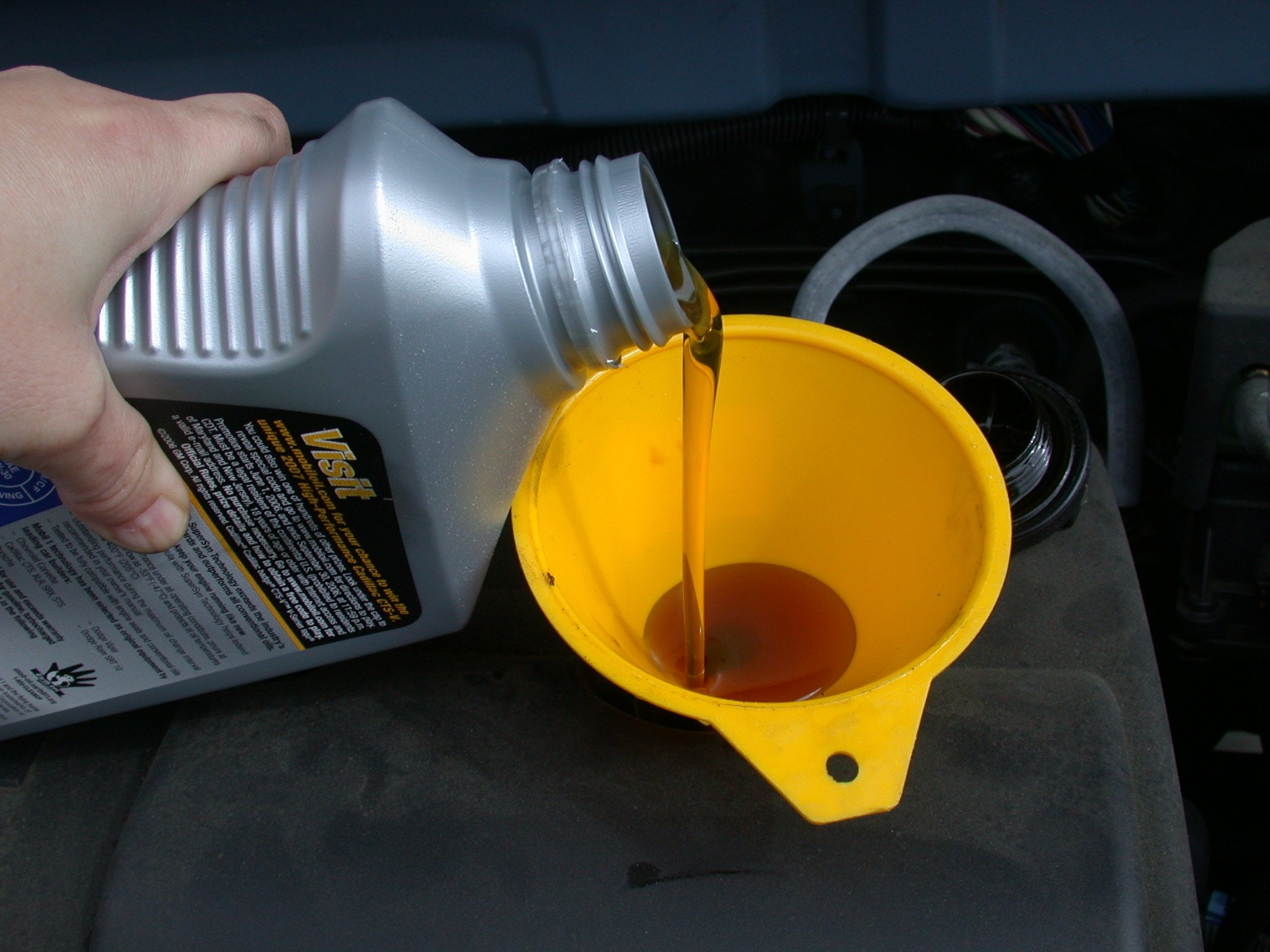 Oil being poured through a funnel